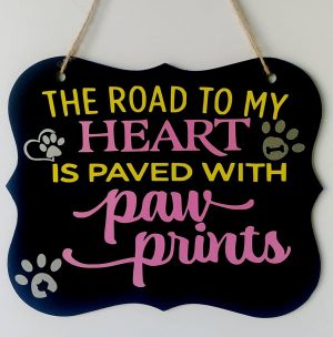 black sign with a quotes for pets in yellow and pink on it